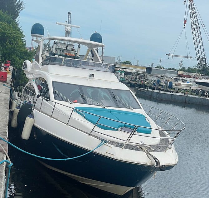 Proa de un yate en el muelle con colchonetas color turquesa